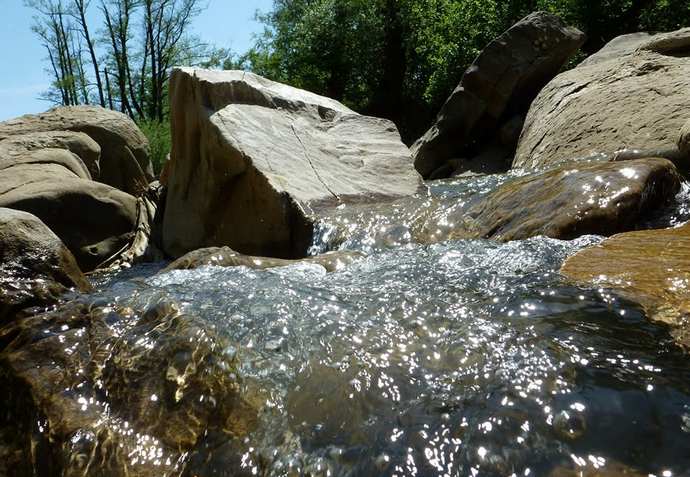 струя воды подмывает камень